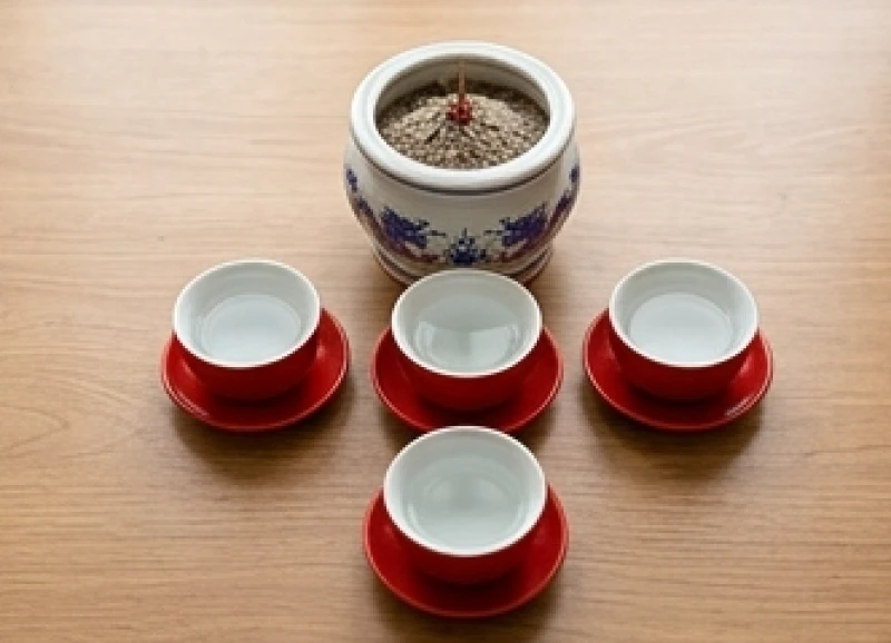 Năm ly nước nhỏ bằng gốm được xếp thành hình chữ thập ngay trước bát hương
