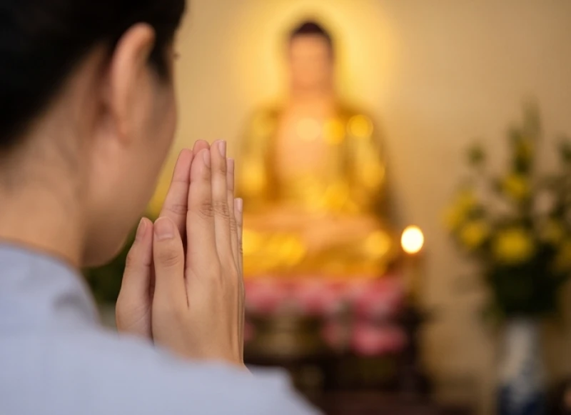 Hai bàn tay chắp trước ngực hình búp sen trong tư thế cúi lạy thành tâm trước chính điện Tam Bảo