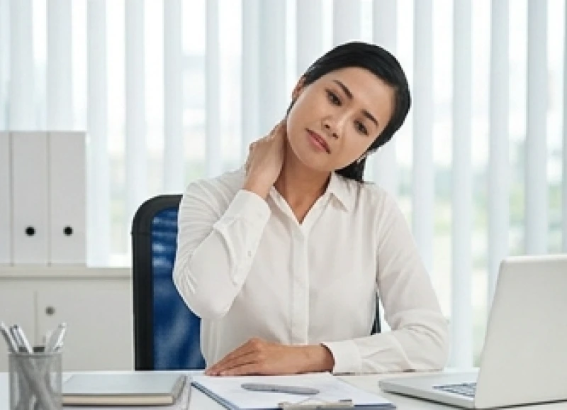 Nhân viên văn phòng thực hiện bài tập giãn cơ cổ tại bàn làm việc để giảm mệt mỏi