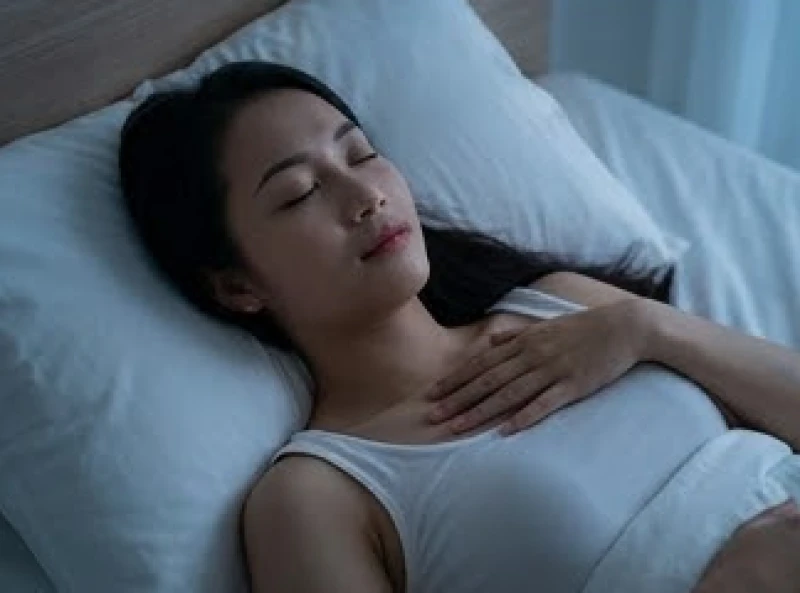 Mơ thấy người yêu cũ chết: Ý nghĩa bối cảnh & cách xử lý 8 Người phụ nữ nhắm mắt thư giãn, thực hiện kỹ thuật hít thở sâu trên giường ngủ để hạ nhịp tim đang đập nhanh