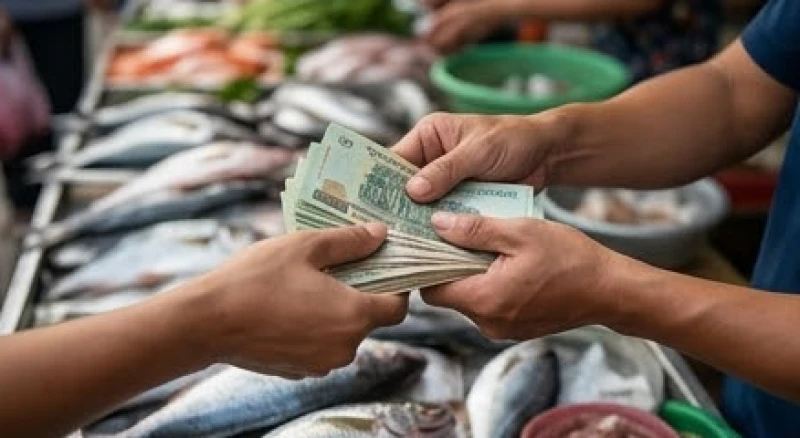 Tiểu thương bán cá đang nhận tiền từ khách hàng sau khi hoàn tất giao dịch tại chợ