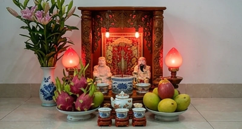 Bàn thờ Thần Tài rực rỡ với đèn sáng và mâm quả sung túc tượng trưng cho dòng chảy tiền bạc