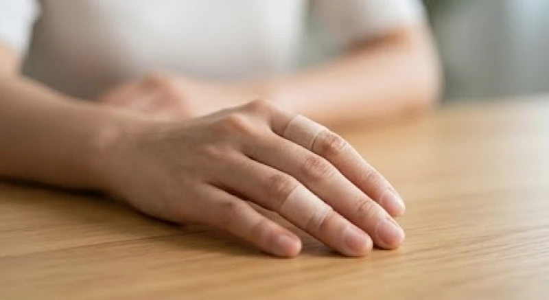 Chảy máu là điềm gì: Giải mã chi tiết và cách hóa giải 1 Một người đang suy tư nhìn vào ngón tay vừa được dán băng cá nhân sau sự cố trầy xước nhỏ ngoài ý muốn
