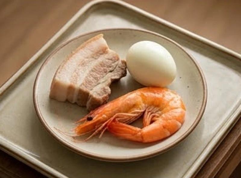 Đĩa lễ mặn thu nhỏ với một miếng thịt ba chỉ luộc, một quả trứng gà và một con tôm luộc đại diện cho bộ tam sinh.