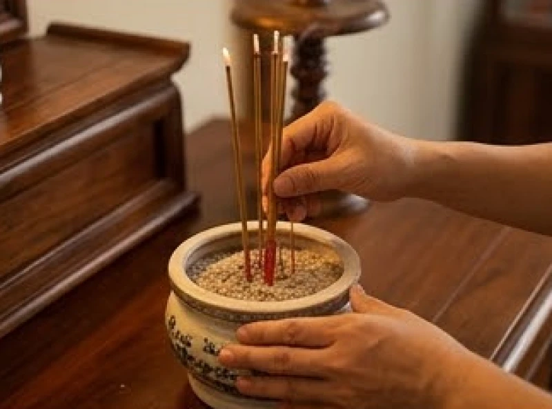 Văn khấn gia tiên ngày rằm: Bài cúng chuẩn và trình tự hành lễ 7 Đôi bàn tay cẩn thận cắm những nén hương đang cháy vào bát hương chính trên ban thờ