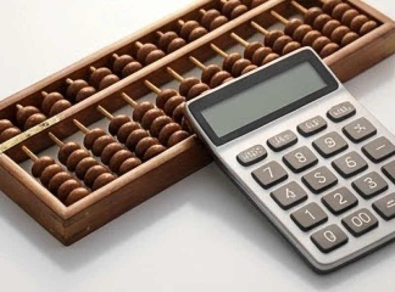 Sim phong thủy tuổi Mùi: Định mức ngân sách và tự luận Kinh Dịch 7 Bàn tính gỗ truyền thống và máy tính hiện đại cùng đặt trên bàn làm việc đại diện cho quá trình tính toán tổng nút