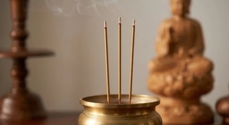 Ba nén hương được cắm thẳng đứng và cách đều nhau trong bát hương trên bàn thờ Phật trang nghiêm
