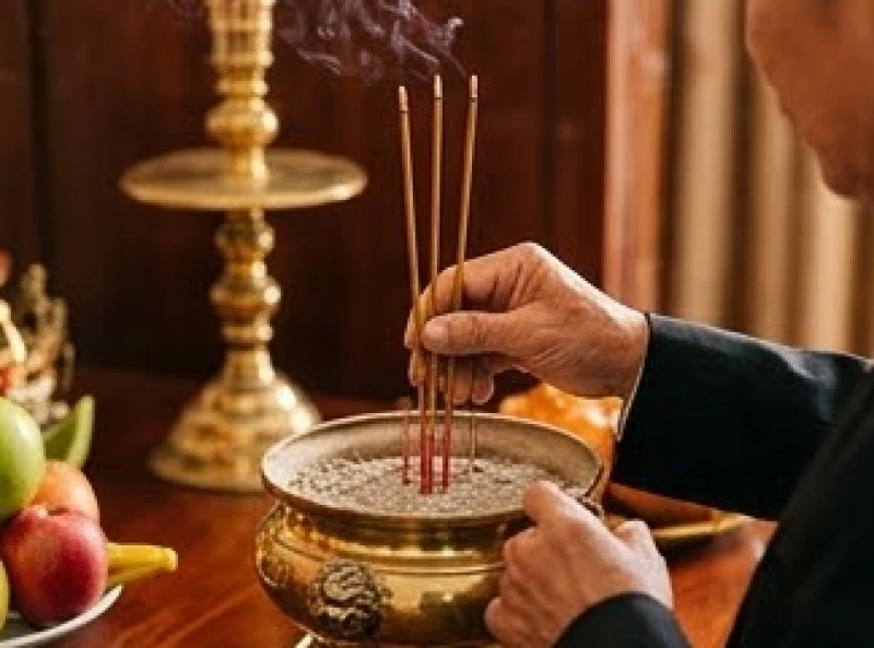 Bàn tay của người chủ lễ cẩn thận cắm thẳng đứng những nén nhang đang cháy đỏ vào chính giữa bát hương