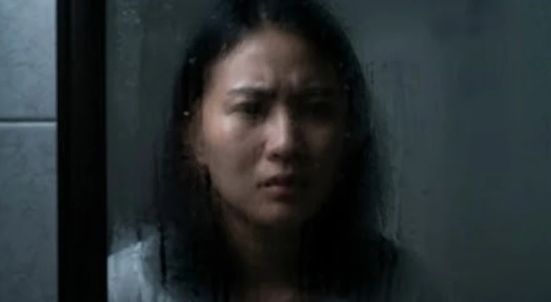 Gương mặt căng thẳng phản chiếu qua chiếc gương mờ hơi nước thể hiện sự uất ức dồn nén