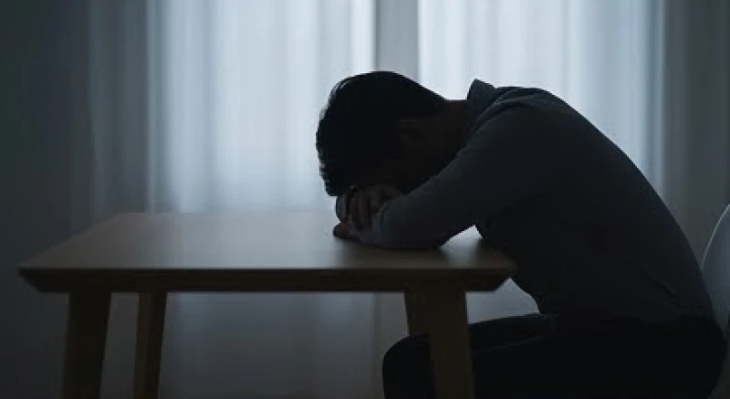 Mơ thấy hai người đàn ông đánh nhau: Điềm báo và số tài lộc 2 Người đàn ông ngồi gục đầu xuống bàn làm việc thể hiện sự mệt mỏi và những áp lực vô hình đang kìm nén