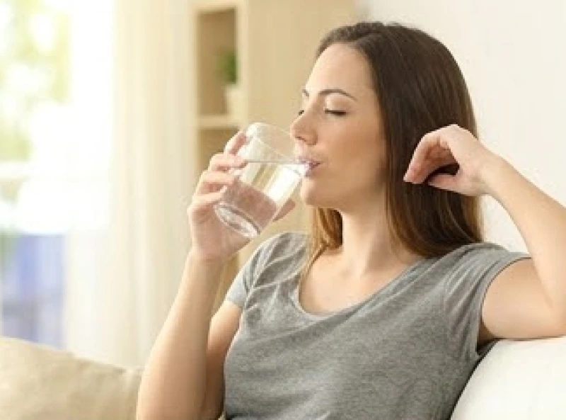 Đường sức khỏe bị đứt đoạn: Ý nghĩa và dấu hiệu hóa giải 1 Người phụ nữ uống một cốc nước ấm trong không gian ngập tràn ánh sáng tự nhiên
