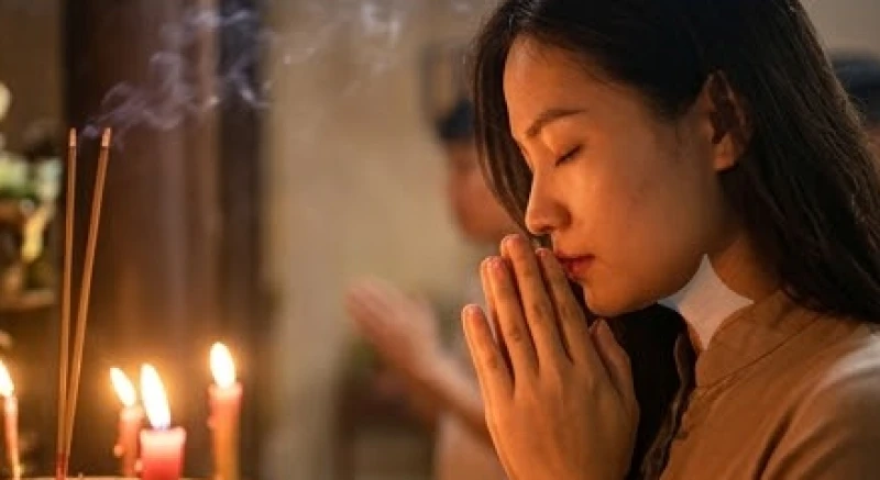 Tín đồ nhắm mắt tĩnh tâm chắp tay vái lạy giữa làn khói hương mờ ảo bên trong khuôn viên tĩnh mịch của Đền Hạ