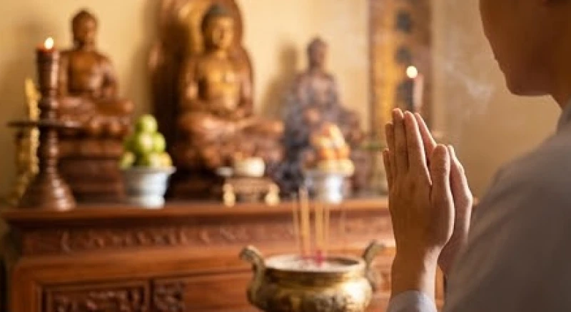 Người đi lễ chắp tay ngang ngực nhẩm đọc lời tạ ơn trước tượng chư Phật uy nghi