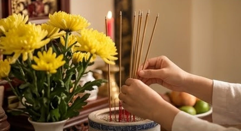 Mơ thấy đám tang người thân đã mất: Giải mã tâm lý & con số 4 Đôi bàn tay cẩn thận sắp xếp nhang đèn và hoa tươi trên ban thờ gia tiên truyền thống