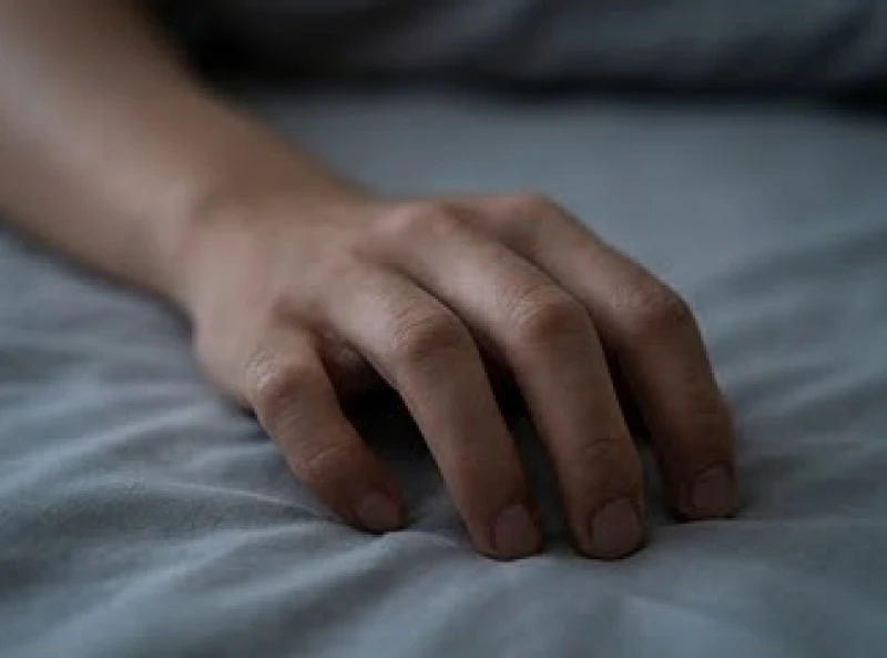 Mơ bị bóng đè: Cơ chế y khoa và giải mã điềm báo dân gian 7 Cận cảnh bàn tay đang cố gắng co cụp từng ngón tay một cách chậm rãi trên bề mặt nệm trải giường
