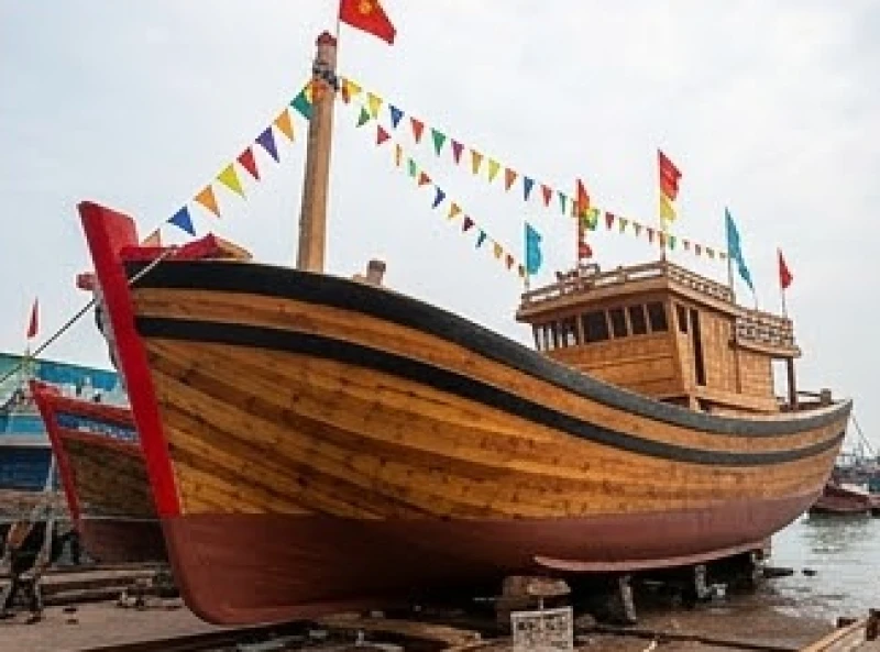 Cờ hoa rực rỡ trong ngày lễ cúng hạ thủy để đưa chiếc tàu cá đóng mới xuống nước an toàn