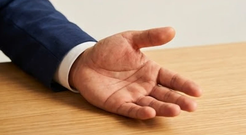 Người đàn ông mặc vest đang chống tay tĩnh tâm lộ rõ đường chỉ tay chữ Xuyên mạnh mẽ