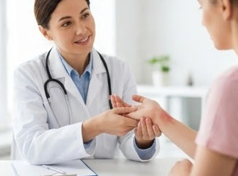 Bác sĩ đang kiểm tra lực nắm của bàn tay và phản xạ thần kinh của bệnh nhân