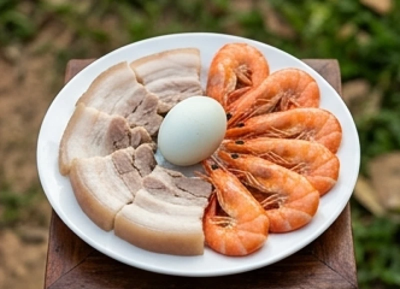 Bộ ba lễ vật tam sên gồm thịt ba chỉ luộc, tôm tươi và trứng vịt được sắp xếp ngay ngắn trên đĩa sứ trắng