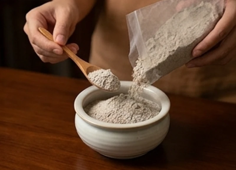 Xúc từng thìa tro nếp tơi xốp đổ nhẹ nhàng vào bát hương mới để tạo nền móng êm ái cho chân nhang