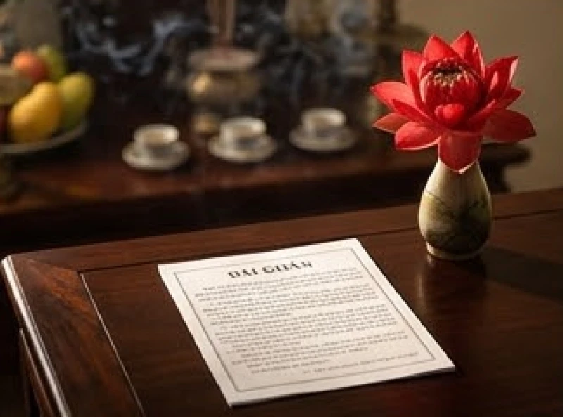 Người đàn ông mặc trang phục lịch sự chắp tay đọc bản văn khấn tạ ơn gia tiên được in sẵn một cách trang nghiêm