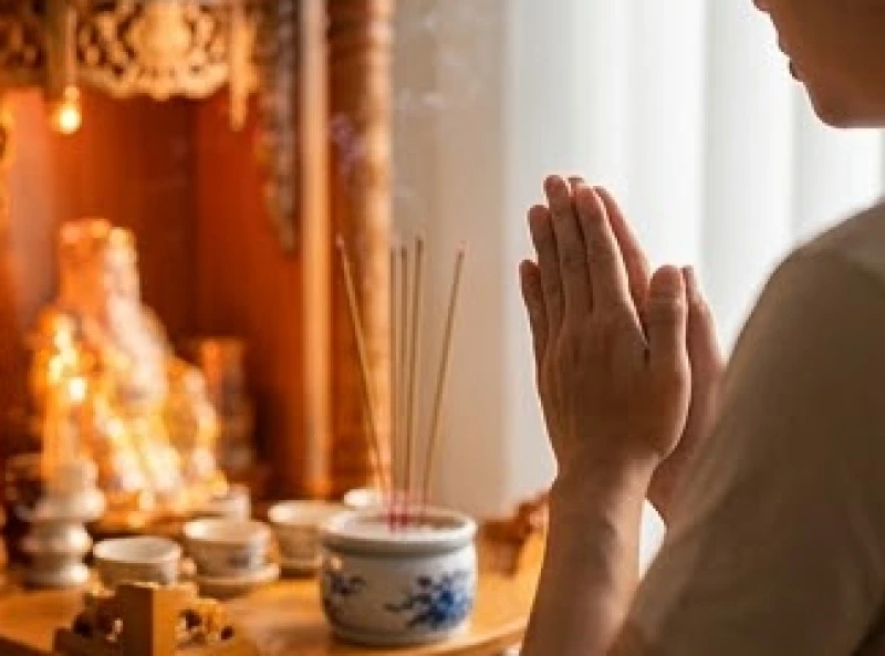 Người kinh doanh đang chắp tay thành kính đọc văn khấn Thổ Địa hàng ngày trước bàn thờ sáng sớm