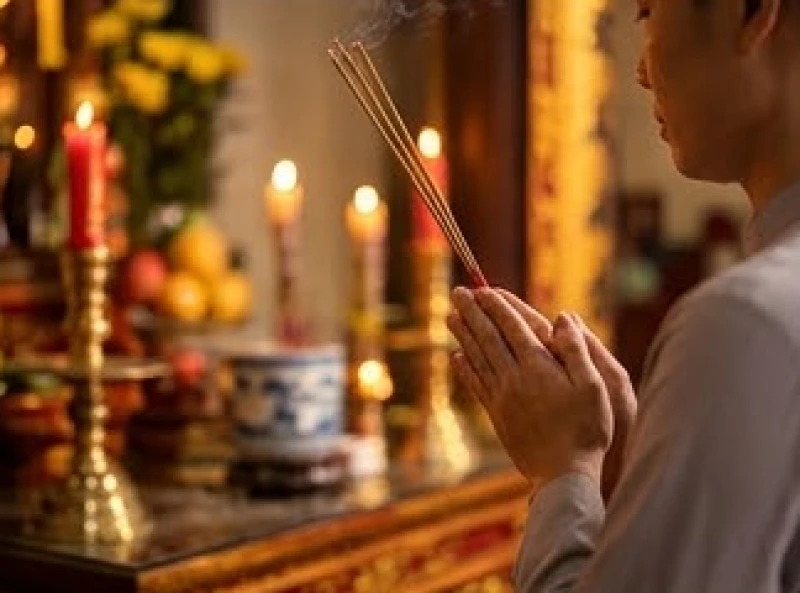 Gia chủ chắp tay đọc bài văn khấn cầu tài lộc buôn bán trước ban thờ với tâm thế tập trung