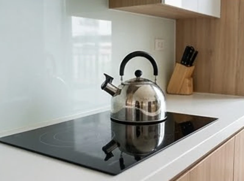 Ấm nước siêu tốc đang đun sôi trên mặt bếp từ mới lắp đặt đánh dấu sự hoàn thiện không gian nấu nướng
