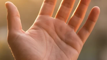 Bàn tay mở rộng dưới ánh sáng tự nhiên hiển thị rõ nét đường chỉ tay tình duyên và các nếp nhăn