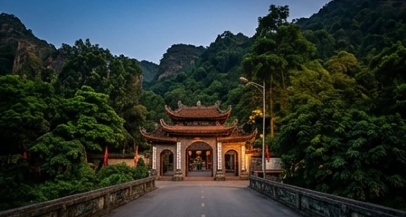 Lối đi rẽ vào cổng đền Cô Bé Chí Mìu với hàng cây xanh mát tĩnh lặng dưới ánh hoàng hôn