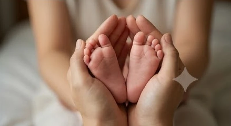 Đôi bàn tay người lớn đang nhẹ nhàng nâng đỡ đôi bàn chân bé xíu của một em bé sơ sinh