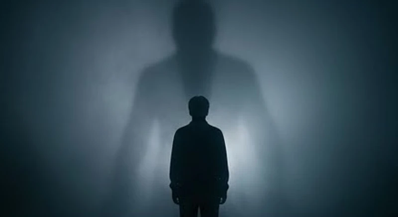 Silhouette của một người đang mệt mỏi đối diện với cái bóng khổng lồ trong tâm trí vô thức