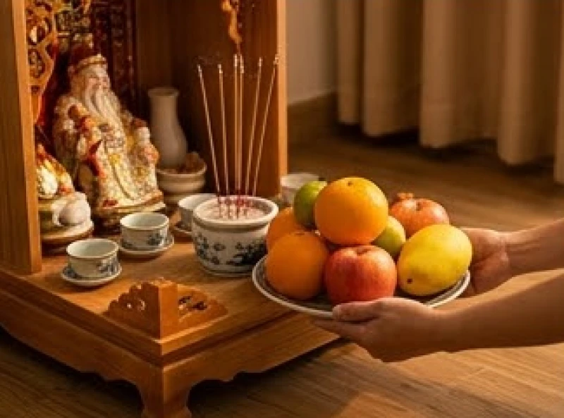 Đĩa trái cây tươi trên bàn thờ được gia chủ hạ xuống cẩn thận sau khi nén nhang đã cháy gần tàn