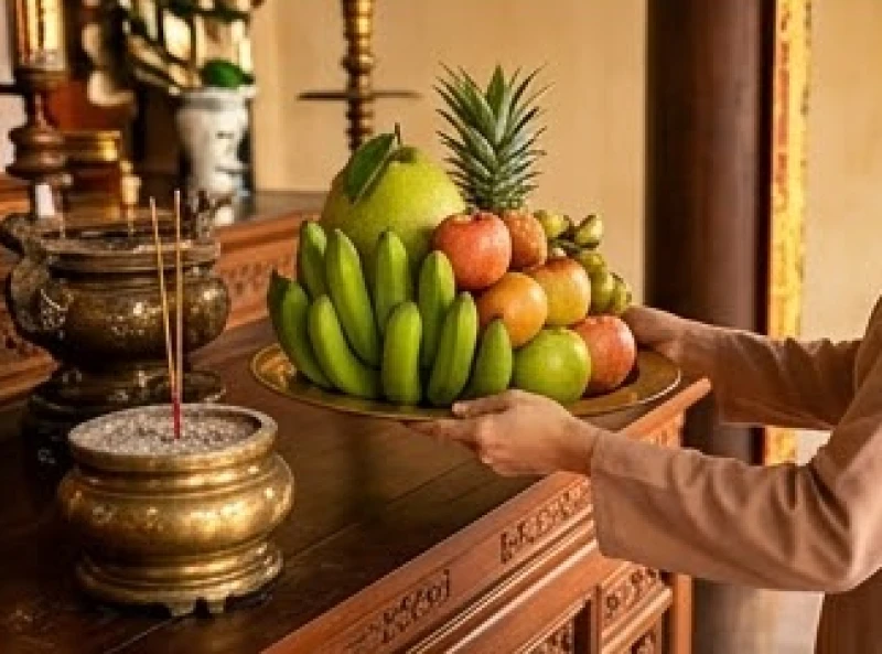 Người đi lễ cẩn thận dùng hai tay xin hạ mâm hoa quả xuống sau khi hương đã tàn