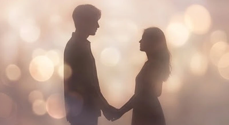 Hai bóng người nắm tay nhau mờ ảo dưới ánh đèn vàng lãng mạn