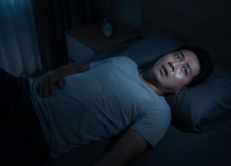 Người đàn ông nằm bất động trên giường, mắt mở to bàng hoàng nhưng không thể cử động