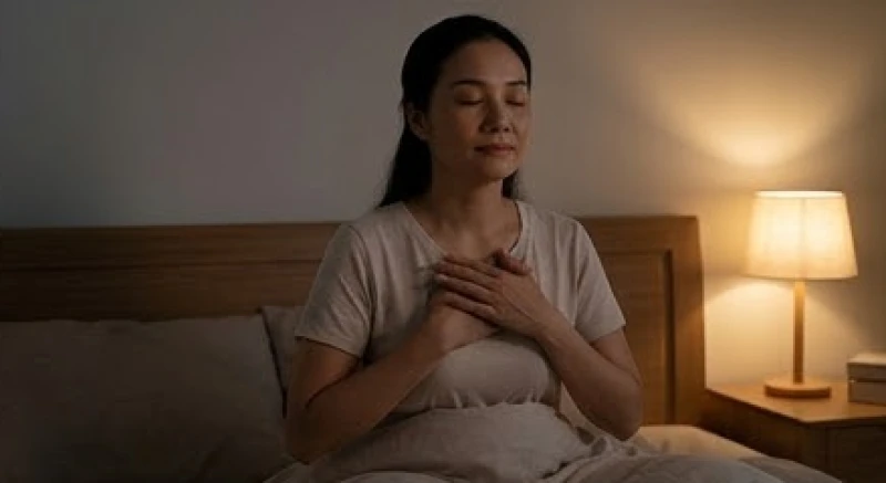 Người phụ nữ ngồi tựa lưng vào giường và thực hành kỹ thuật hít thở sâu để lấy lại bình tĩnh giữa đêm