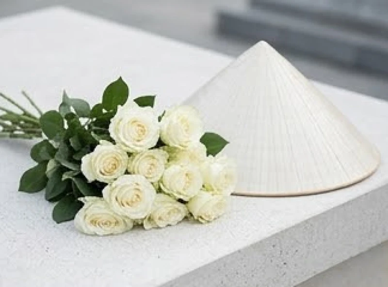 Bó hoa hồng trắng tươi tắn và nón lá truyền thống được dùng làm vật phẩm dâng lễ tại Côn Đảo.
