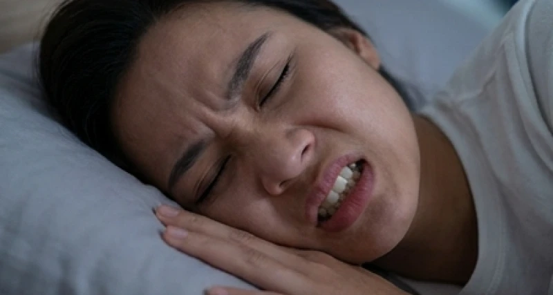 Mơ thấy răng sâu bị vỡ: Điềm báo tâm linh và góc nhìn y khoa 5 Cận cảnh gương mặt một người đang nhíu mày và nghiến chặt hàm răng trong giấc ngủ sâu