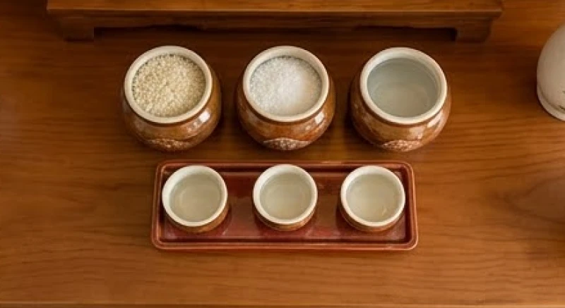 Ba hũ gạo, muối, nước và kỷ năm chén được xếp theo đúng lớp không gian trên mặt bàn thờ Thần Tài
