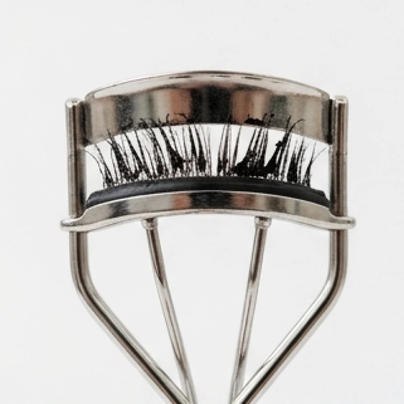 Thao tác kẹp bấm mi cơ học trên nền lông mi đang chuốt mascara dày cộm
