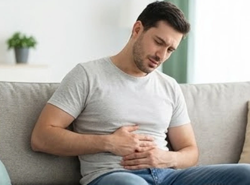 Đường sức khỏe bị đứt đoạn: Ý nghĩa và dấu hiệu hóa giải 2 Người đàn ông xoa nhẹ vùng bụng thể hiện sự mệt mỏi về hệ tiêu hóa