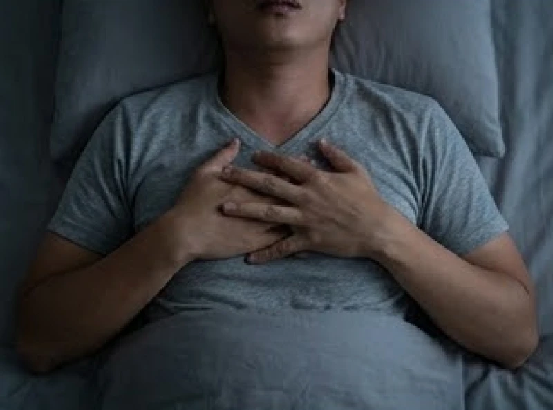 Mơ bị bóng đè: Cơ chế y khoa và giải mã điềm báo dân gian 4 Bàn tay ôm chặt lấy lồng ngực thể hiện cảm giác khó thở và áp lực đè nén trong cơn hoảng loạn