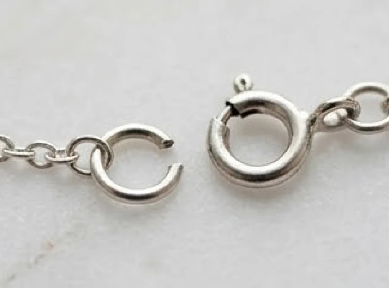 Chiếc khóa càng cua và khuyên nối tròn của dây chuyền bạc bị hở mép do tác động kéo giật mạnh