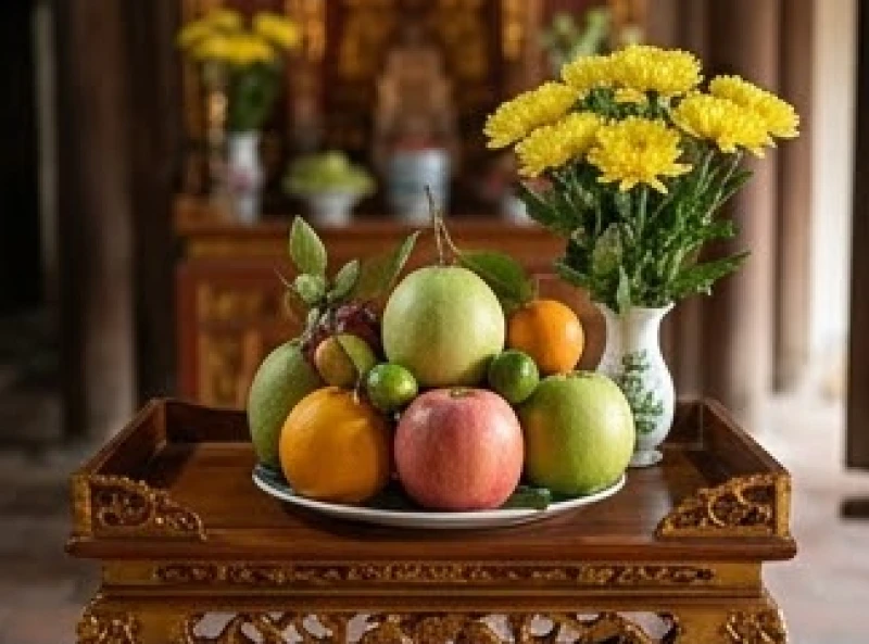 Một đĩa trái cây ngũ quả tươi ngon cùng bình hoa cúc vàng bày biện trang trọng để dâng lên ban Công Đồng
