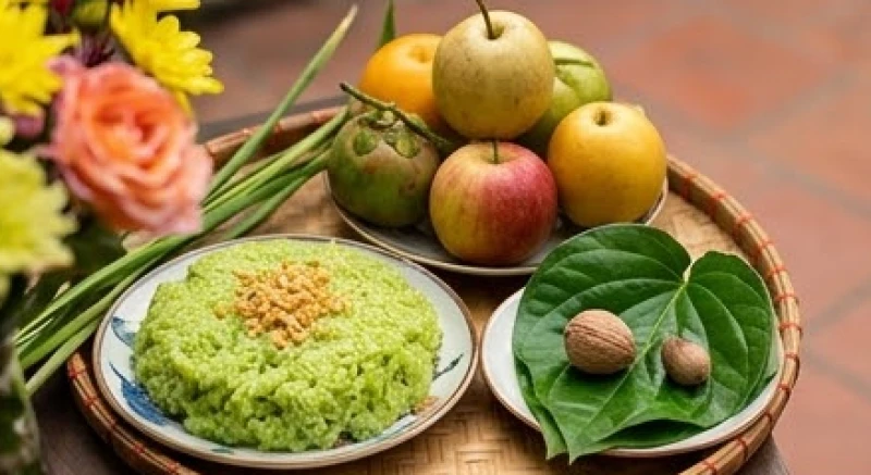 Mâm cúng chay ngoài trời gồm đĩa xôi cốm xanh, trái cây tươi và trầu cau têm cánh phượng