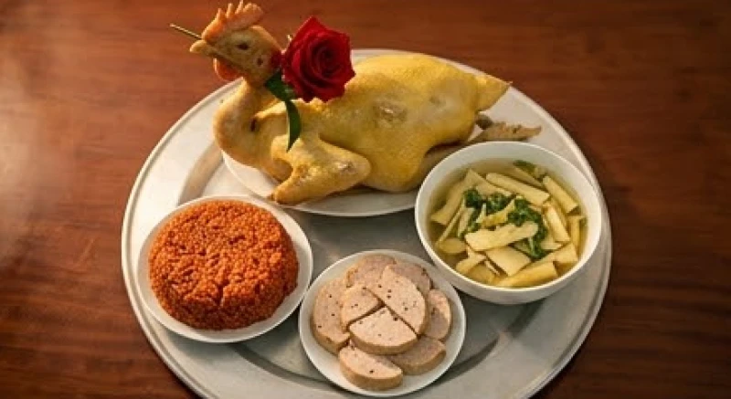 Mâm cỗ mặn cúng giỗ đầu tươm tất với gà luộc ngậm hoa hồng, xôi gấc, giò lụa và bát canh miến nấu măng
