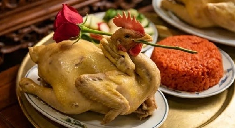 Mâm lễ mặn truyền thống dâng thần linh bao gồm gà luộc chéo cánh ngậm hoa hồng tươi và đĩa xôi nếp gấc đỏ rực