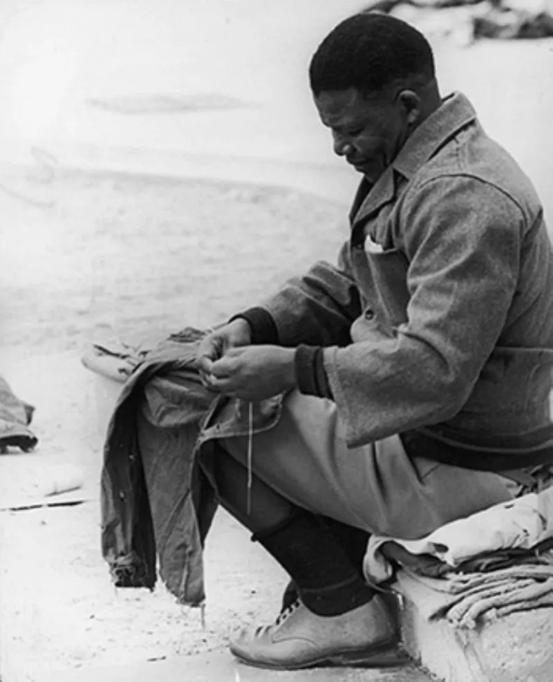 Mandela khâu áo trong sân nhà tù năm 1966. 