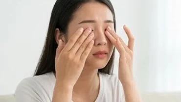 Người phụ nữ đang xoa bóp nhẹ vùng mí mắt mỏi mệt khi tìm hiểu mắt giật liên tục là điềm gì